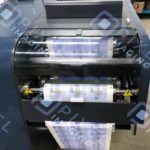 Custom-printed product labels being printed on a label printing machine.