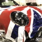 Unfinished installation of a custom-printed vinyl vehicle wrap of the United Kingdom Union Jack flag on a Cooper Mini car.